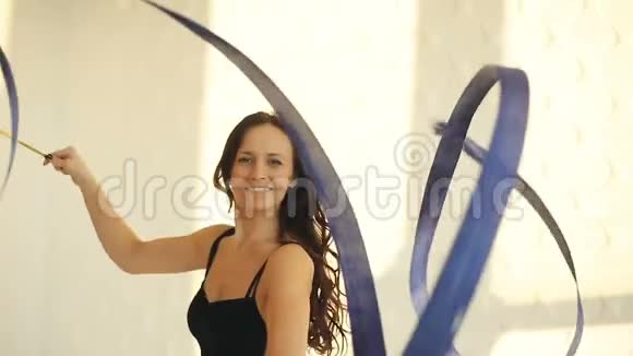 布吕内特年轻女子肖像舞蹈艺术体操现代风格窗前穿黑色彩带视频的预览图