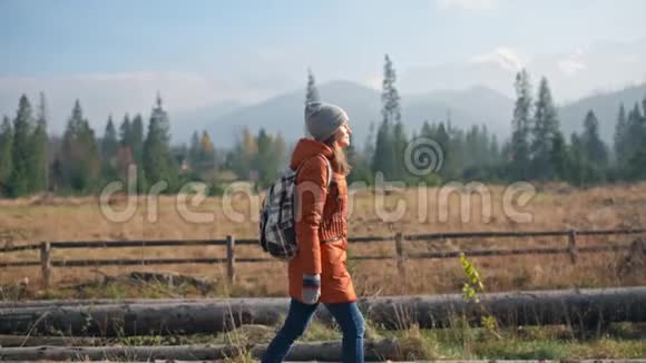 女孩走在美丽的路上靠近山脉秋季慢动作视频的预览图