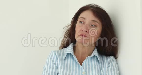 退休妇女在白色背景上皱着眉头视频的预览图