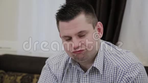 一个情绪化的男人坐在婚礼沙龙的沙发上对他的女人展示的衣服做出反应视频的预览图