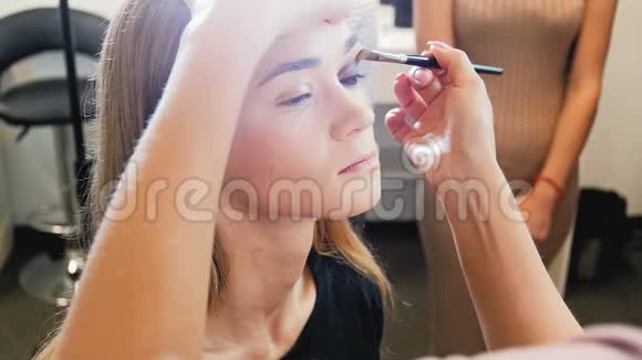 专业化妆师在工作室工作的特写慢镜头视频形象设计师在模特脸上化妆视频的预览图