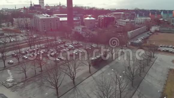 在现代和历史建筑附近的大型停车场和高大的红色烟囱的空中景观视频的预览图