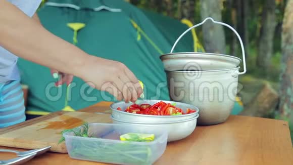 一个年轻的女人在野餐时用沙拉把柠檬汁挤碗里视频的预览图