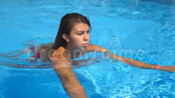 年轻晒黑的女人在空池中提神和游泳的肖像布鲁内特女孩漂浮在酒店和视频的预览图