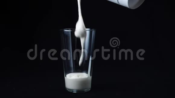 慢动作的美味奶昔与冰淇淋填充透明玻璃在黑色背景框架鸡尾酒视频的预览图