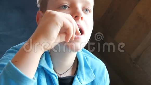 蓝眼睛的帅哥少年在快餐店吃薯条抬头看了看视频的预览图