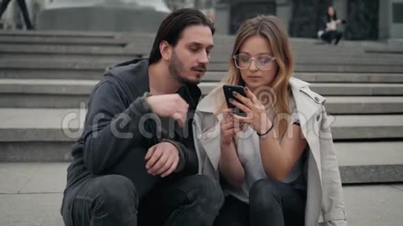 美丽的男人和女人走在街上通过智能手机制作自拍使用应用程序和游戏时尚视频的预览图