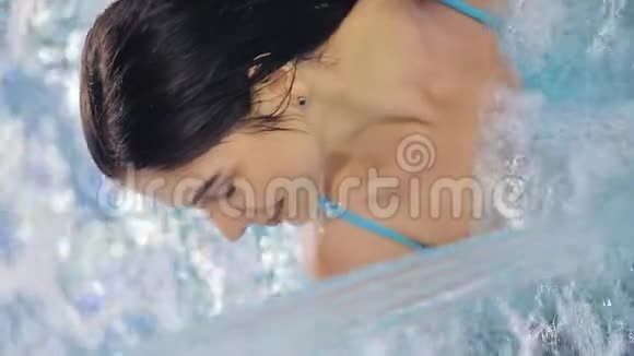 垂直视频年轻女子在游泳池里享受水水上有氧运动移动设备垂直框架视频的预览图