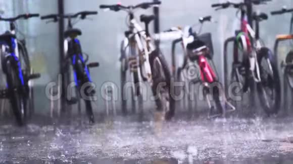 停放的公共自行车租赁摊在沥青上浇下深雨慢动作3840x2160视频的预览图