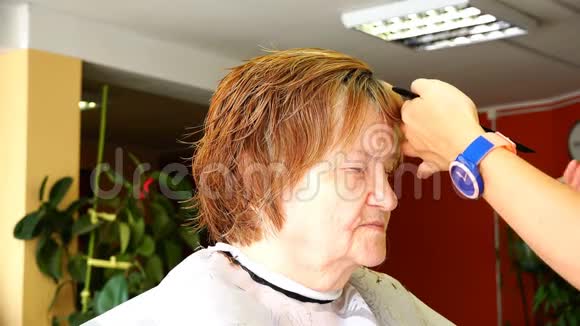 给一位老年妇女剪刘海时用专业剪刀摆动视频的预览图