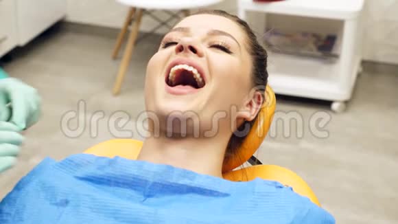 一位女牙医检查一位年轻女子牙齿视频的预览图
