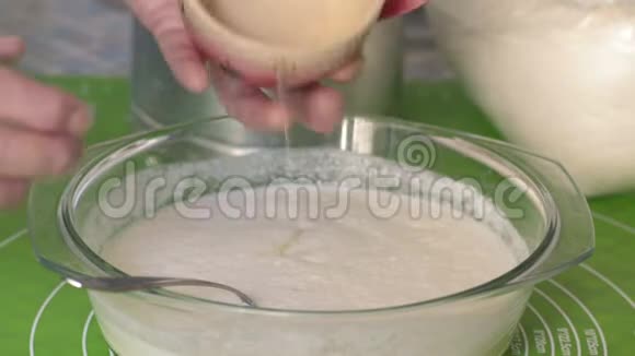 特写成熟的女人从杯蛋白蛋在玻璃器皿与配料的面团和搅拌视频的预览图