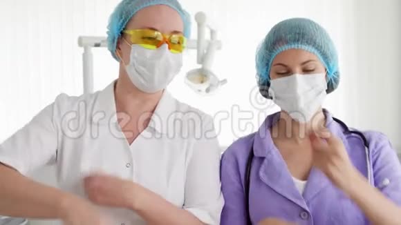 两个戴着面具戴着帽子的傻笑女医生在医院里跳舞在休息时玩得开心视频的预览图