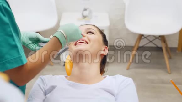 一位牙医检查一位年轻妇女牙齿颜色阴影视频的预览图