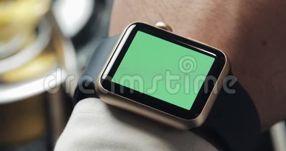 关闭商务人员手与智能手表绿色屏幕色度键背景舒适的咖啡馆视频的预览图