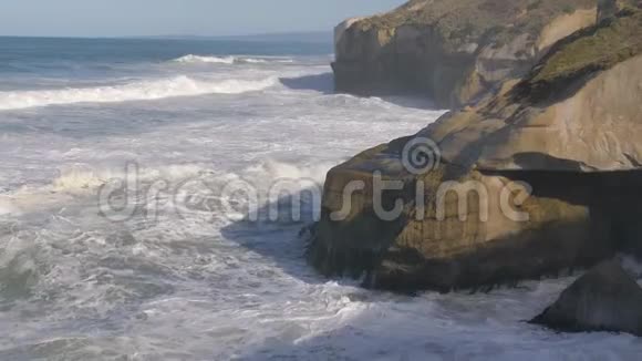 新西兰奥塔哥半岛隧道海滩海浪冲击悬崖缓行视频的预览图