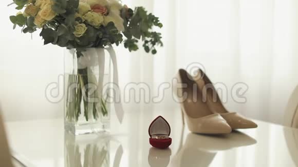 结婚纪念日结婚戒指和新娘花束放在桌子上视频的预览图