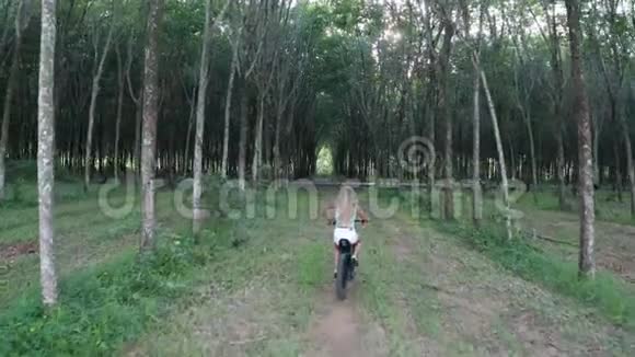 森林中电动自行车上妇女的鸟瞰图视频的预览图