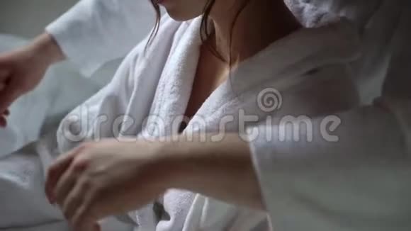 一对年轻夫妇坐在浴袍里拥抱和牵手视频的预览图