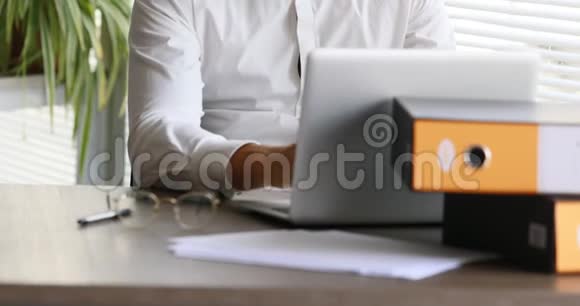 男人对着电脑打字然后看着相机视频的预览图