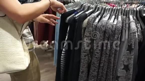 女人在买衣服的时候看衣架视频的预览图