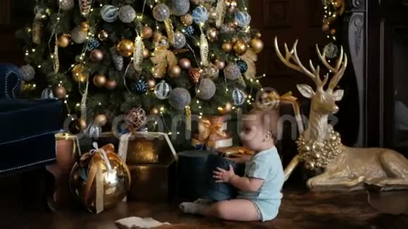 小女孩爬在圣诞树旁手里拿着礼物视频的预览图