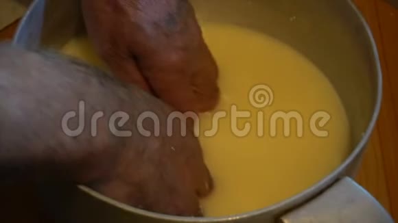 把热发酵的羊牛奶放在木桶里从羊牛奶中提取大量奶酪视频的预览图