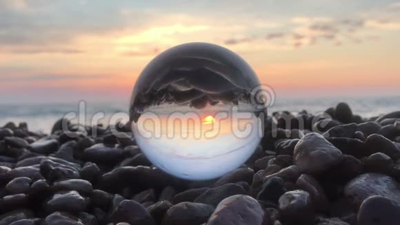 在石头上的水晶球里阳光洒在水面上沙滩上风景中充满了夕阳的倒影视频的预览图