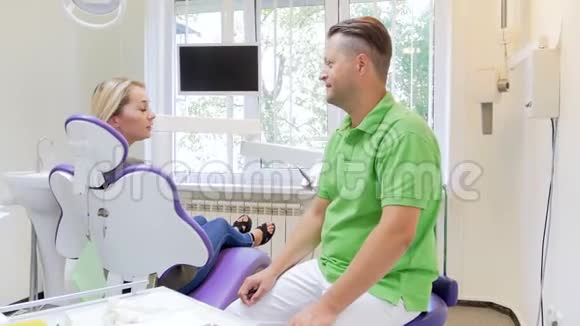 4k张金发美女坐在牙医椅上向牙医展示疼痛牙齿的镜头视频的预览图