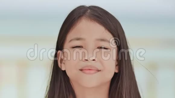 一个迷人的菲律宾女学生正摆姿势在热带海滩的白色蓝色背景上进行面部特写视频的预览图