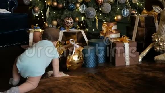 小女孩爬在圣诞树旁手里拿着礼物视频的预览图