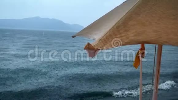 海滩遮阳伞落下的雨滴特写4k视频视频的预览图