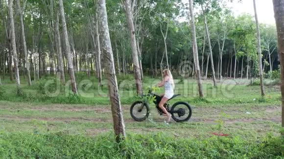 森林中电动自行车上妇女的鸟瞰图视频的预览图