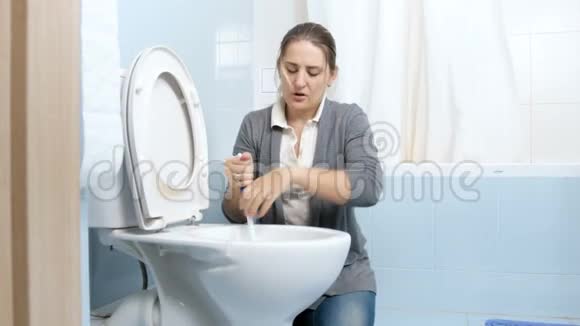4K镜头疲惫的家庭主妇用刷子清洗肮脏的厕所视频的预览图