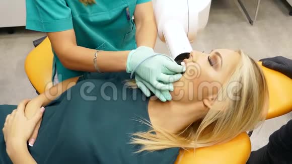 一位牙医给一位女性病人拍了一张的牙齿X光片视频的预览图