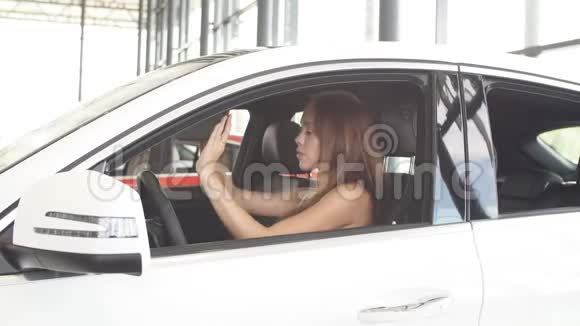 幸福的女司机在车展室的新车里拿着车钥匙视频的预览图