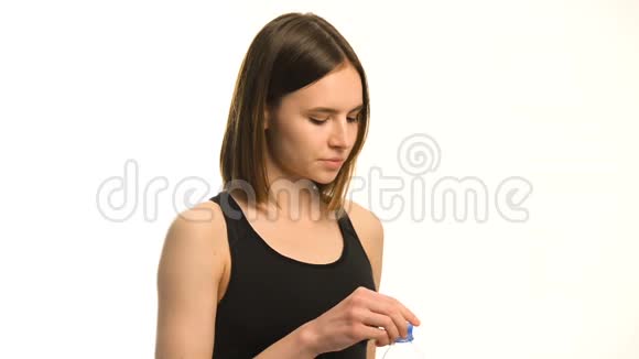 积极的女性健身模式后锻炼饮用水在工作室白色背景视频的预览图