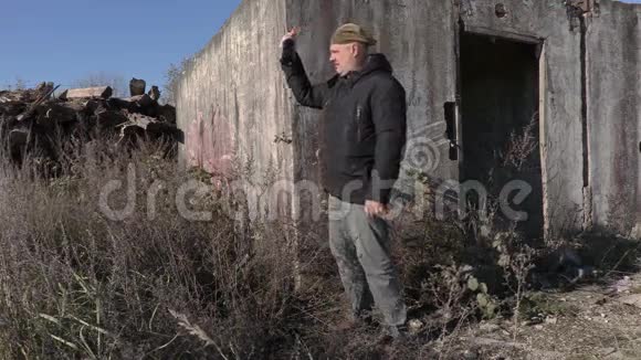一个醉汉在废弃的大楼旁拿着空酒瓶视频的预览图