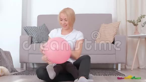 迷人的年轻金发妈妈和她迷人的女儿一起玩粉色气球视频的预览图