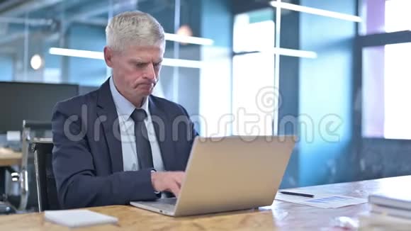 在笔记本电脑上工作的中年商人视频的预览图