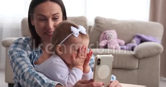 爱玩的女孩子妈妈在家里用手机自拍视频的预览图