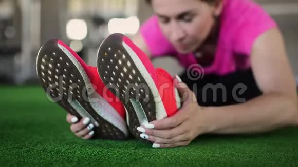 穿粉色鞋子的健身女性特写在健身房或家里锻炼伸展运动美腿跳跃的细节视频的预览图