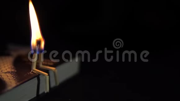 两根燃烧的火柴在黑暗中落在一本书上爱的概念高清高清视频的预览图