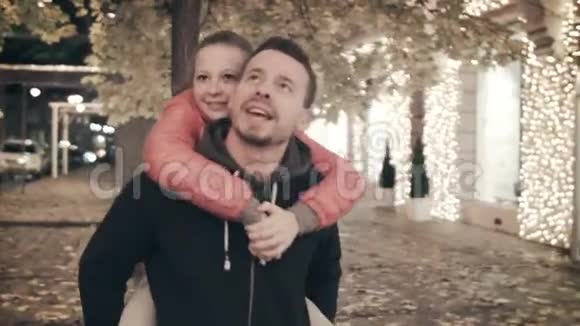 一个幸福的家庭在假日在城里散步父亲背着一个流泪的女儿视频的预览图