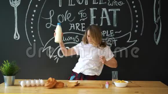 快乐的女人在厨房里和牛奶跳舞视频的预览图