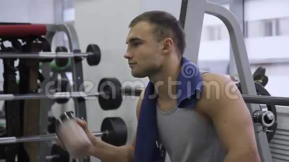 年轻男性运动员的肖像他正在健身房里喝瓶子里的蛋白质奶昔视频的预览图