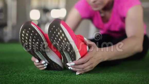 贴身女健身粉鞋在健身房或家里锻炼伸展运动美腿跳跃的细节视频的预览图