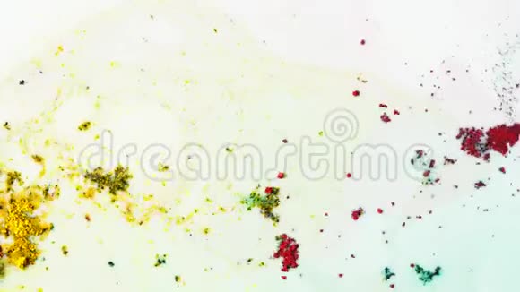 亮黄色粉末与其他颜料混合在白色液体表面有五颜六色的污渍色彩丰富的概念关闭视频的预览图