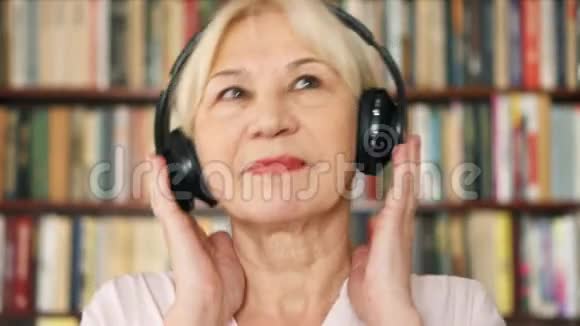 开朗的老年女性听音乐带无线耳机退休的梅洛曼跳舞视频的预览图