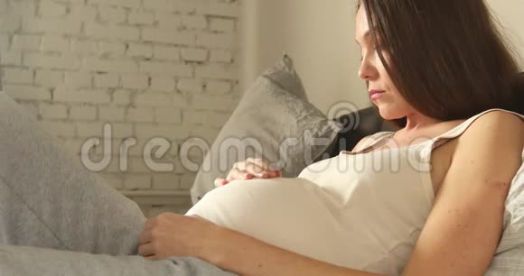 可怜的孕妇躺在沙发上视频的预览图